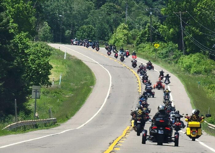 Motorcycle riders and members of the Combat Vets Motorcycle Association move together down the road in staggered formation to raise awareness for Veteran Suicide.